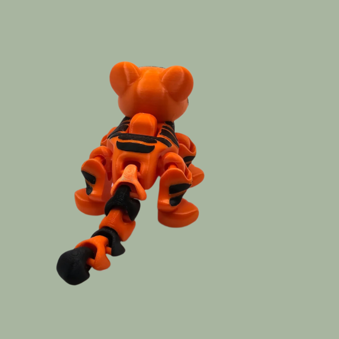 3D printed orange tiger with black stripes, with button mechanism to create a running motion
