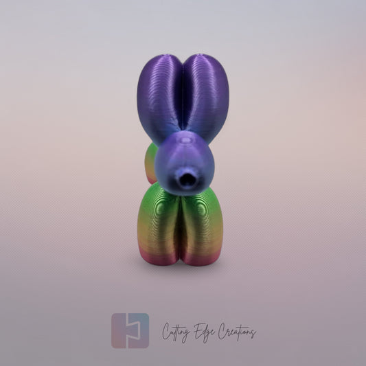 Unique rainbow balloon dog figurine, 3D printed with a smooth, glossy finish. A colourful and fun sculpture for home or office decor