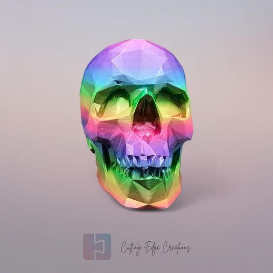 3D-printed low-poly rainbow skull figurine, uniquely coloured with a vibrant gradient. Handmade in the UK, 12cm tall, and perfect for modern home decor or gothic-inspired interiors