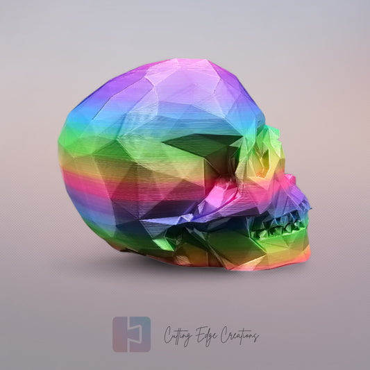 3D-printed low-poly rainbow skull figurine, uniquely coloured with a vibrant gradient. Handmade in the UK, 12cm tall, and perfect for modern home decor or gothic-inspired interiors