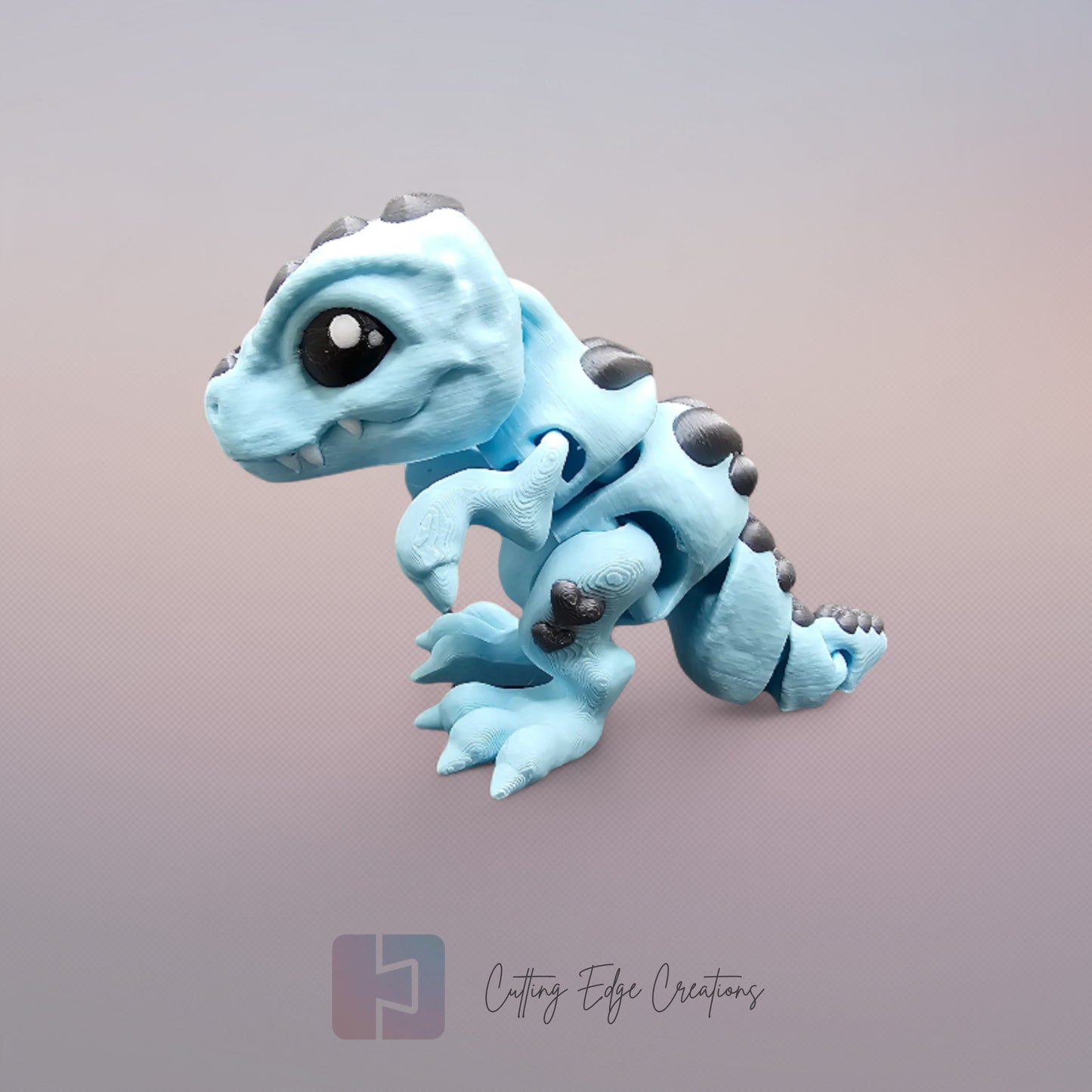 3D printed Love O’Saurus Rex dinosaur toy in light blue with black heart-shaped markings, designed as a flexible and posable fidget toy. Made in the UK by Cutting Edge Creations
