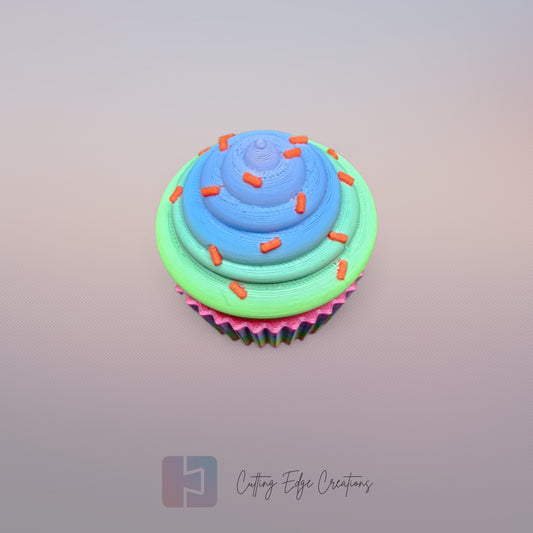 3D-printed Large Rainbow Cupcake Clicker fidget toy in vibrant rainbow colours with a built-in clicking mechanism. A fun, sensory stress relief toy, perfect for kids and adults. Handmade in the UK, 6cm wide and 5.5cm tall. Ideal for fidgeting, focus, and anxiety relief
