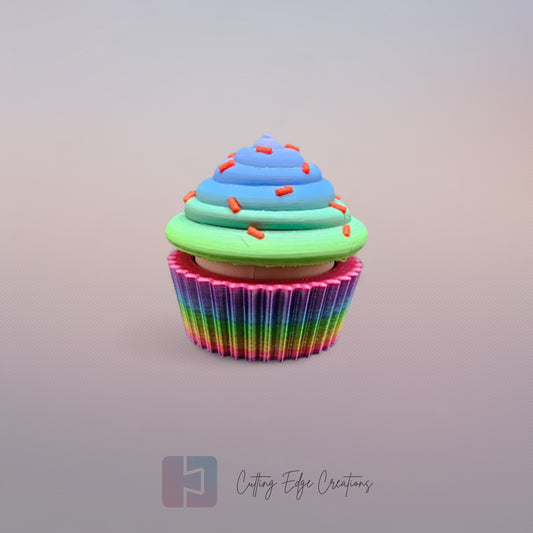3D-printed Large Rainbow Cupcake Clicker fidget toy in vibrant rainbow colours with a built-in clicking mechanism. A fun, sensory stress relief toy, perfect for kids and adults. Handmade in the UK, 6cm wide and 5.5cm tall. Ideal for fidgeting, focus, and anxiety relief