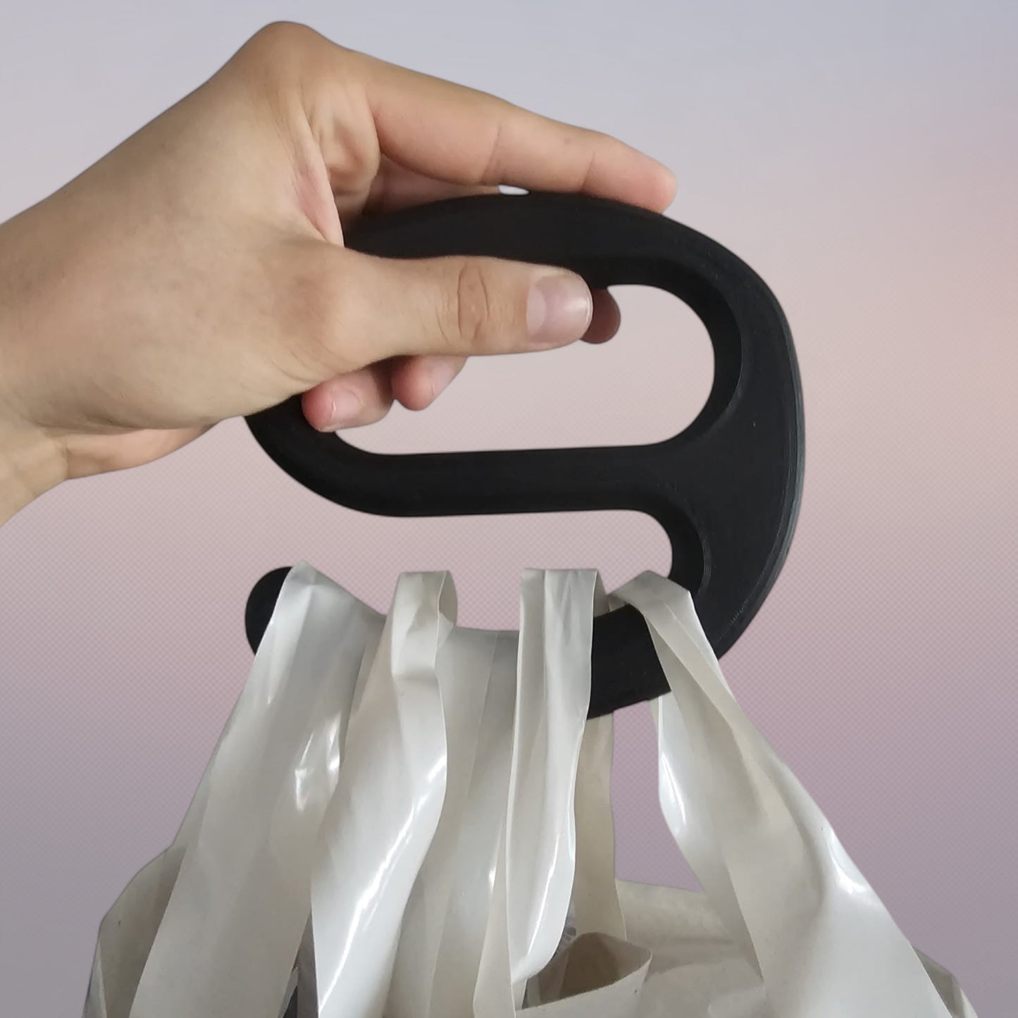A strong black plastic handle holding multiple Aldi shopping bags in one hand against a white background.