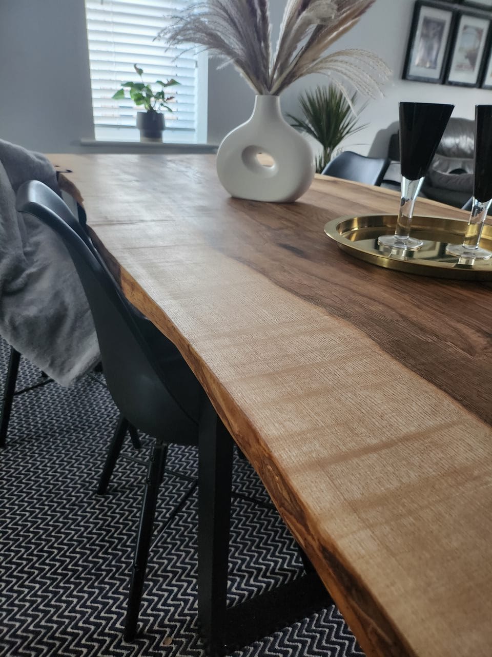 Handmade solid wood dining table with live edge design, styled in a modern home interior with pampas vase and black dining chairs – sustainable UK craftsmanship by Cutting Edge Creations.