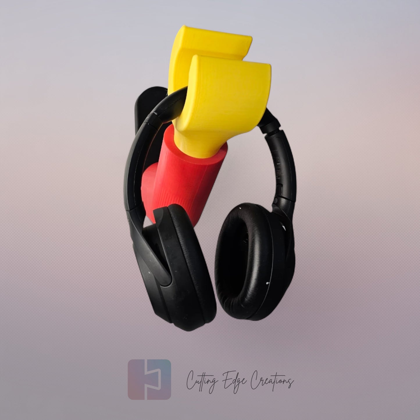 3D printed block style arm in various colours, with black base for wall or freestanding mounting, with chunky yellow hand to hold headphones or coats