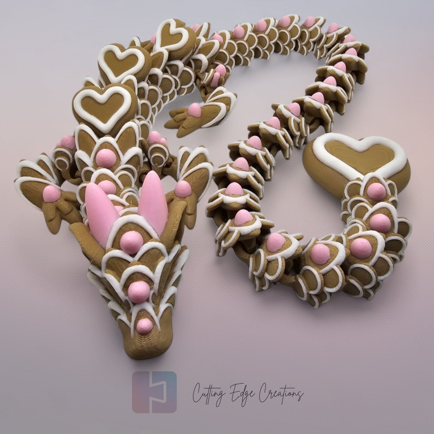 3D printed cookie style articulated dragon with pink and white icing details
