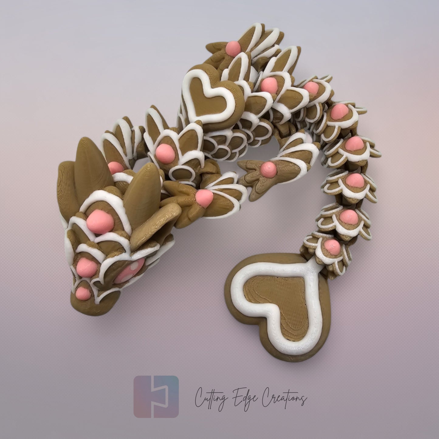 3D printed cookie style articulated dragon with pink and white icing details