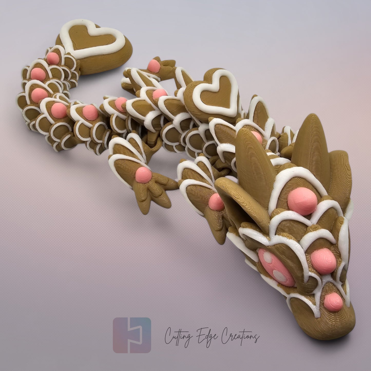 3D printed cookie style articulated dragon with pink and white icing details