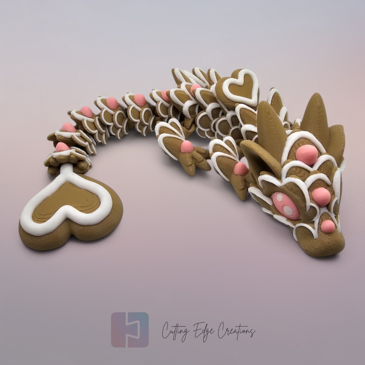 3D printed cookie style articulated dragon with pink and white icing details