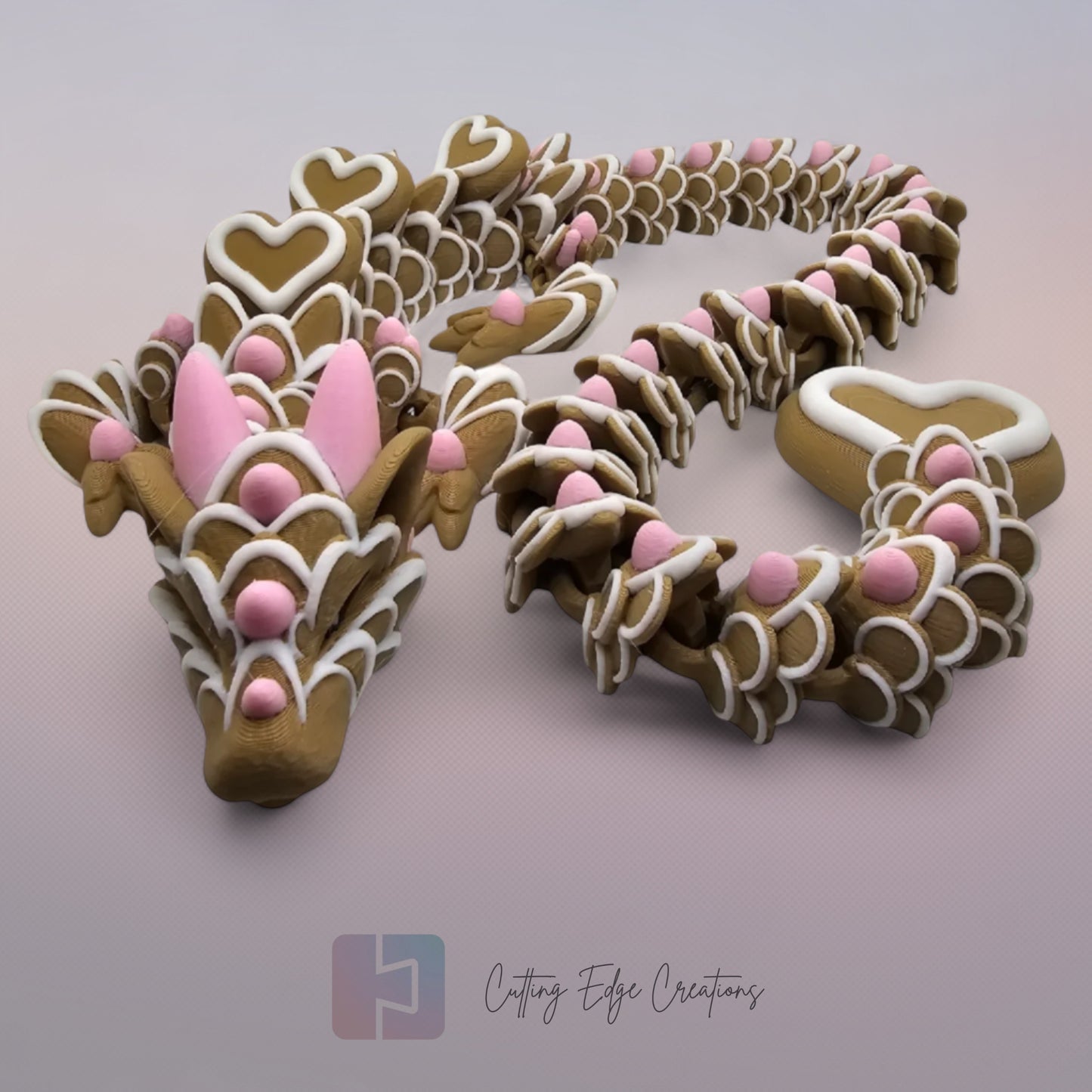 3D printed cookie style articulated dragon with pink and white icing details