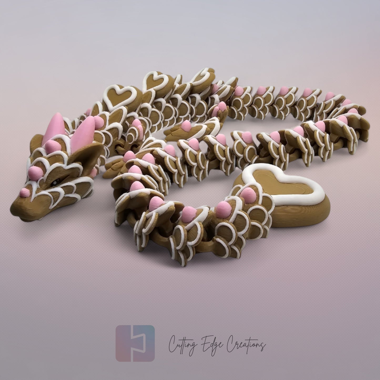 3D printed cookie style articulated dragon with pink and white icing details