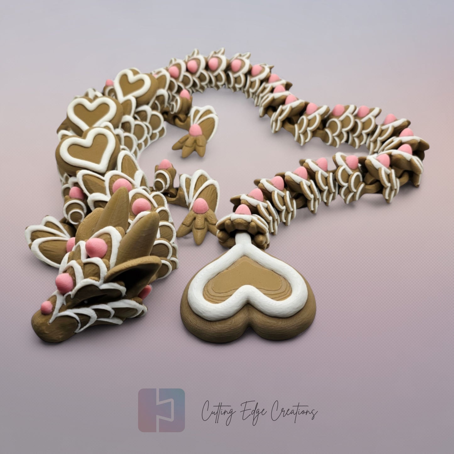 3D printed cookie style articulated dragon with pink and white icing details