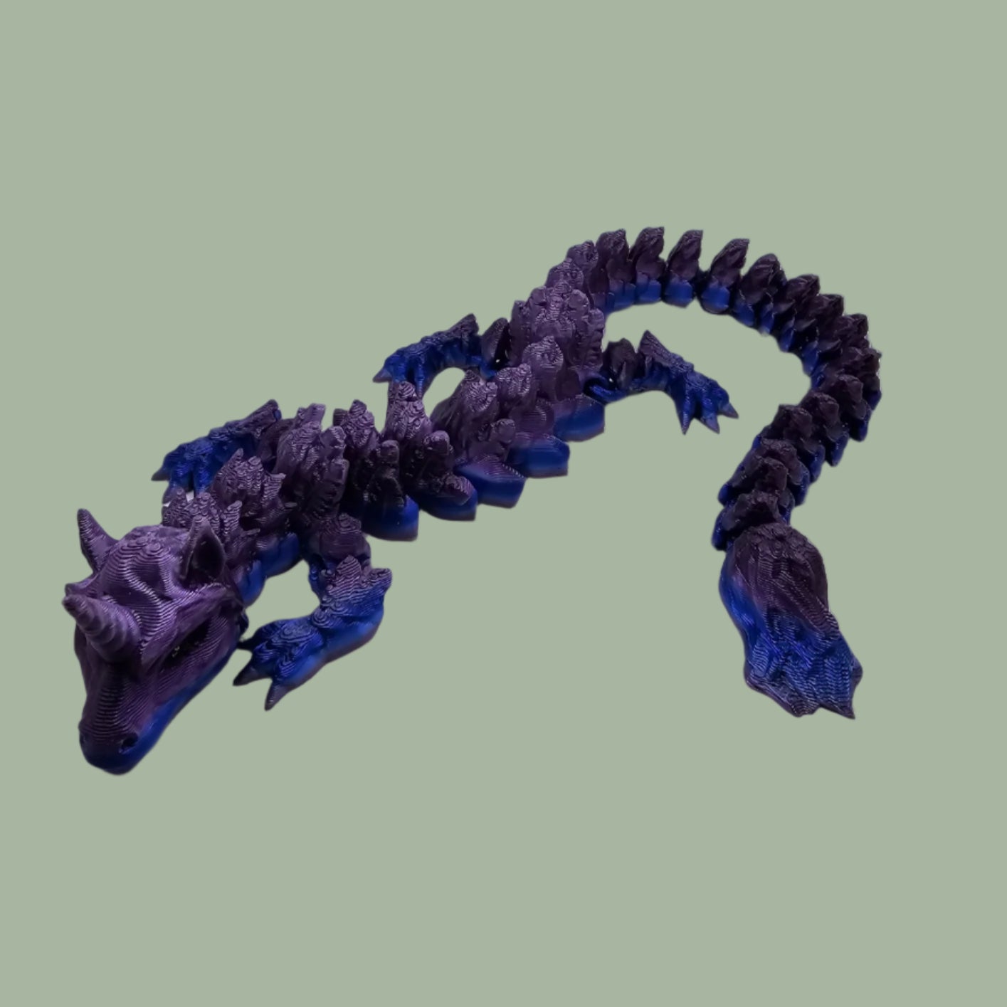 3D printed articulated unicorn dragon with horn on the head, in a purple and blue colour