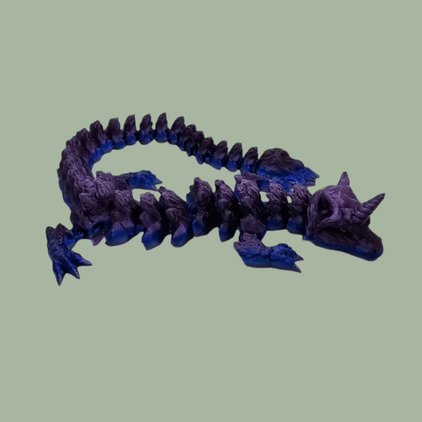 3D printed articulated unicorn dragon with horn on the head, in a purple and blue colour