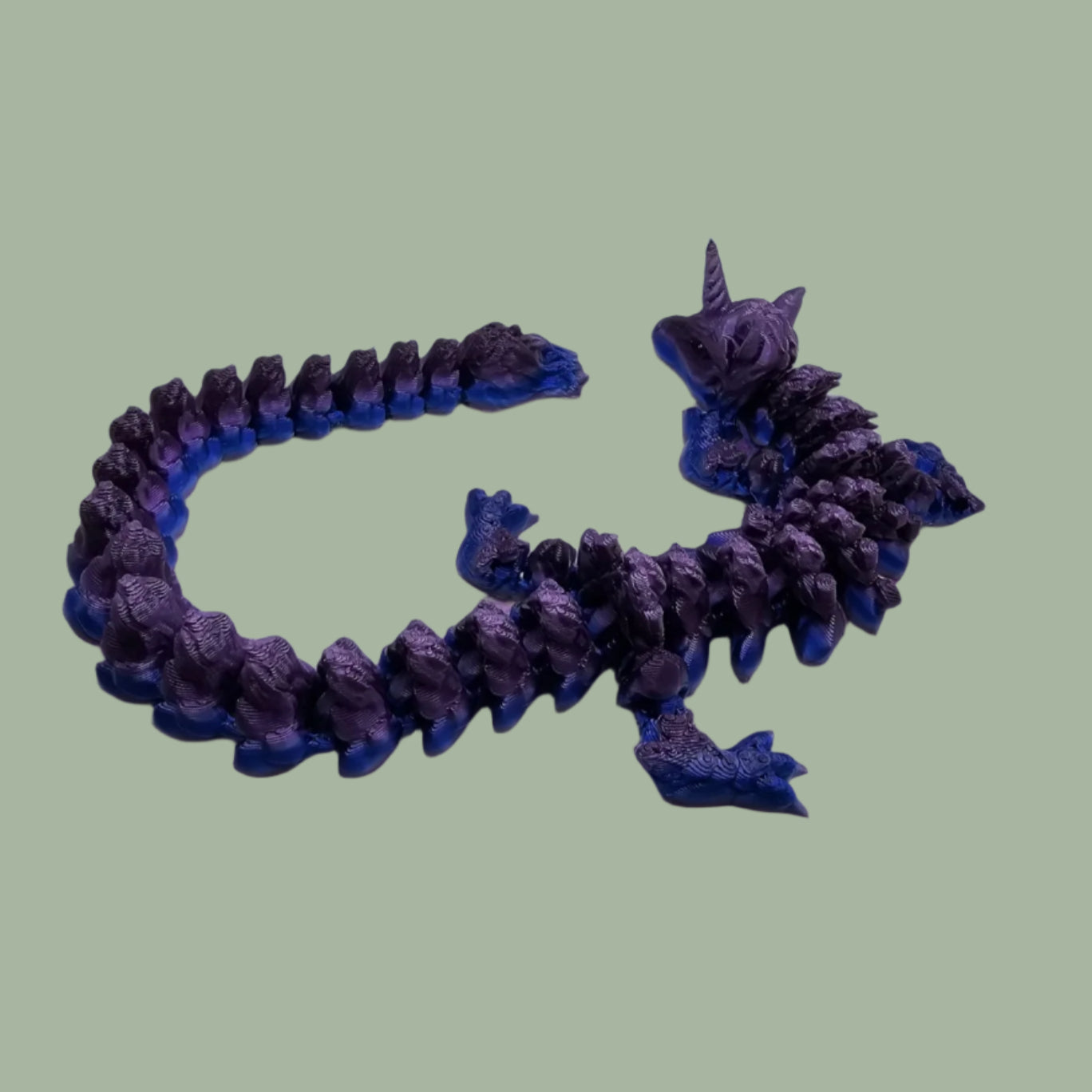 3D printed articulated unicorn dragon with horn on the head, in a purple and blue colour