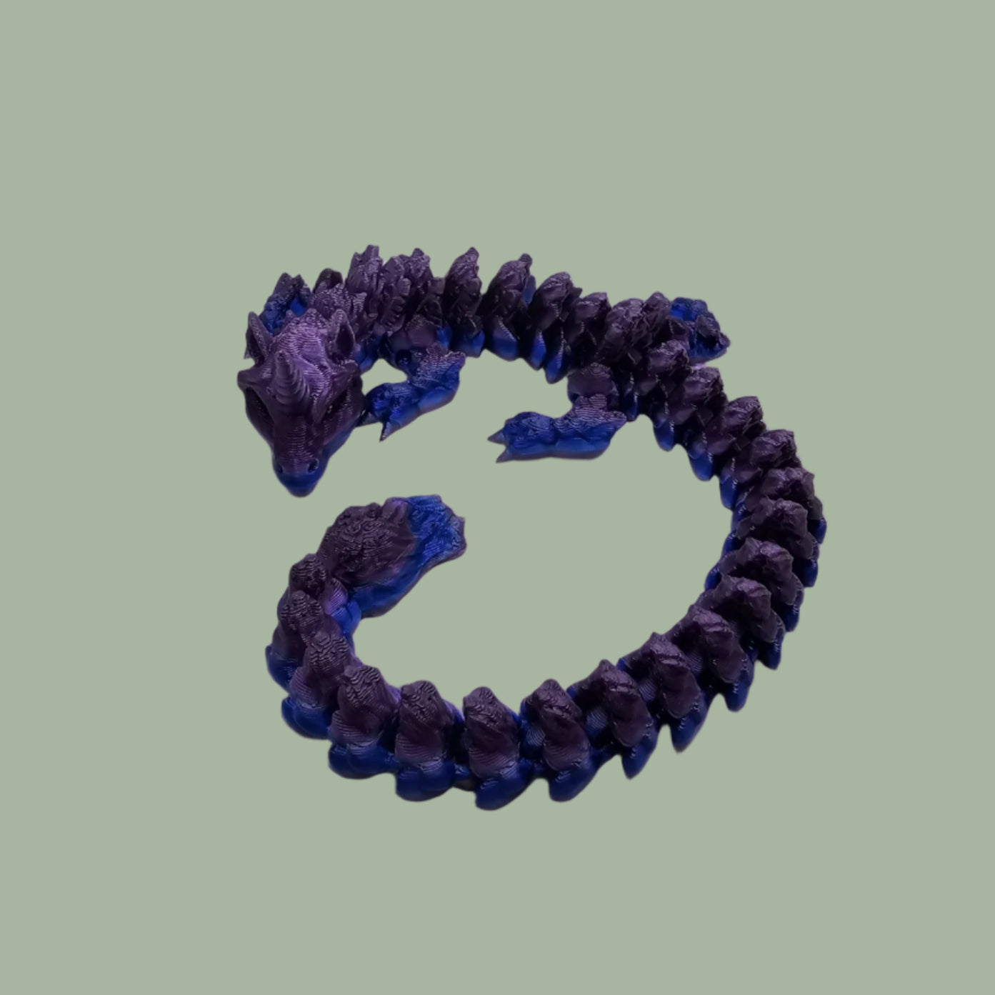 3D printed articulated unicorn dragon with horn on the head, in a purple and blue colour