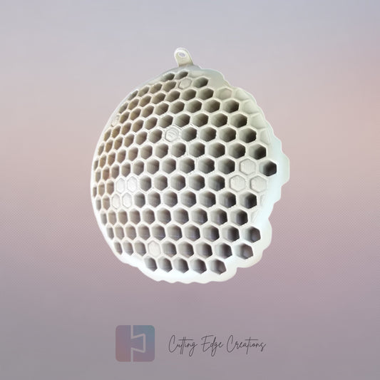 A 3D printed fake wasp nest with a honeycomb pattern, mounted under a wooden shed roof to deter real wasps.