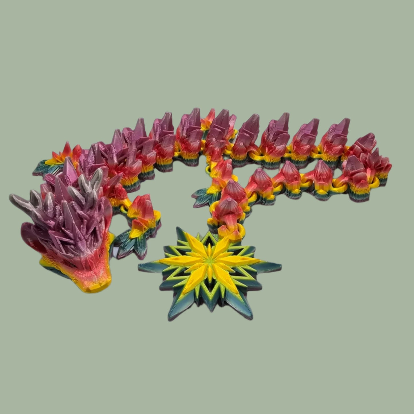 3D printed articulated dragon with snowflake details and large snowflake on tail, in a rainbow colour
