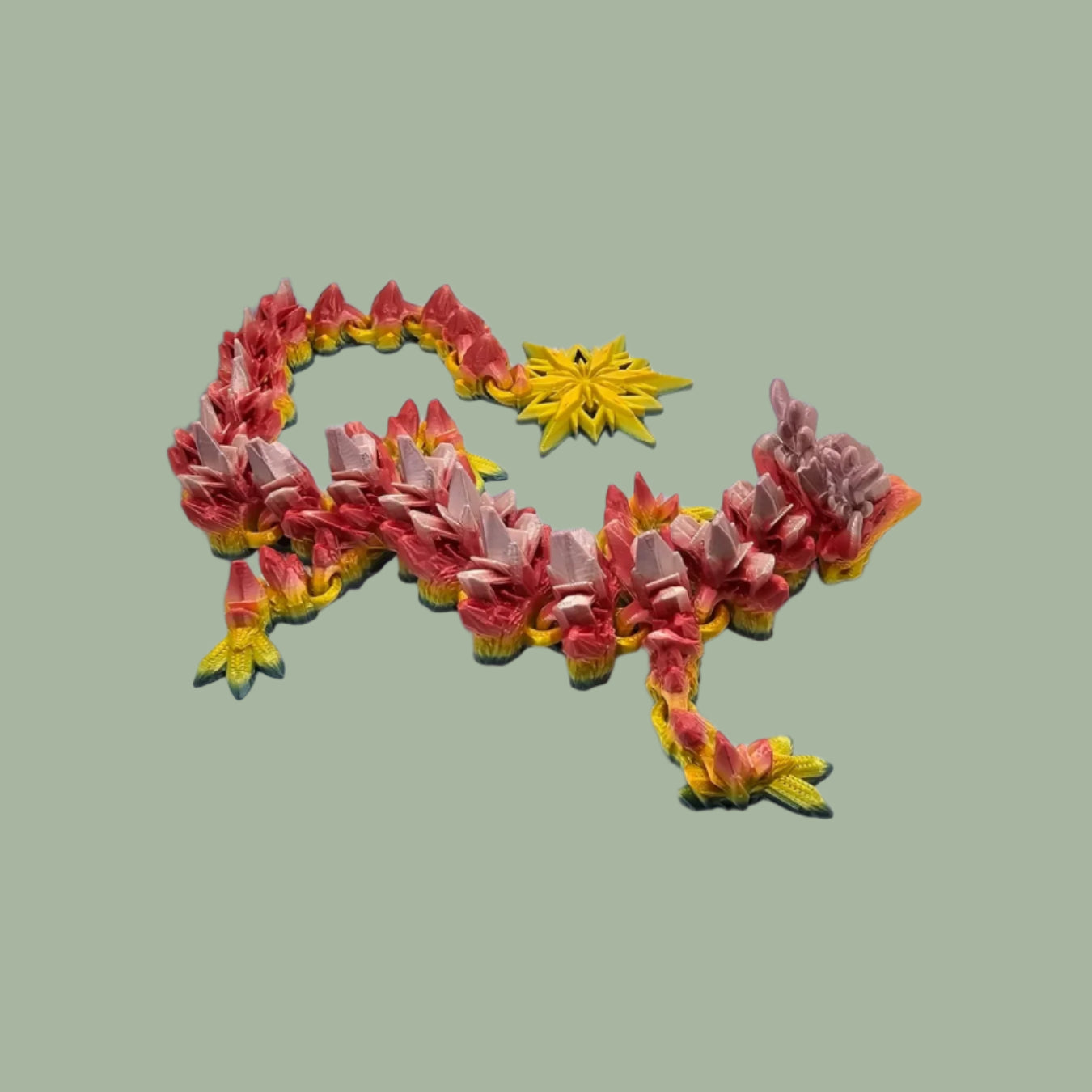 3D printed articulated dragon with snowflake details and large snowflake on tail, in a rainbow colour
