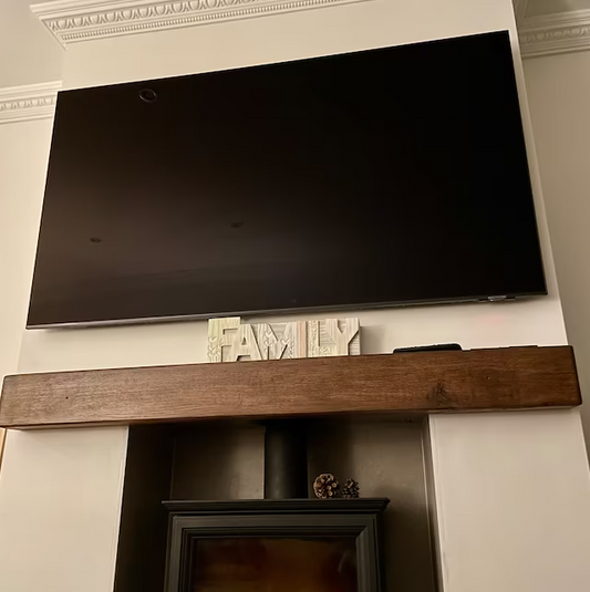 Handmade rustic oak beam mantel mounted on wall with concealed fixings