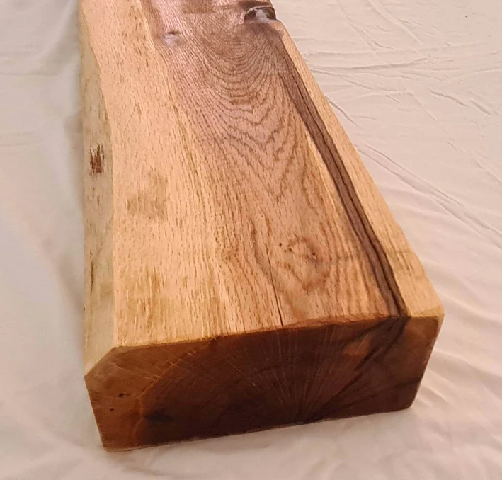 Handmade rustic oak beam mantel mounted on wall with concealed fixings