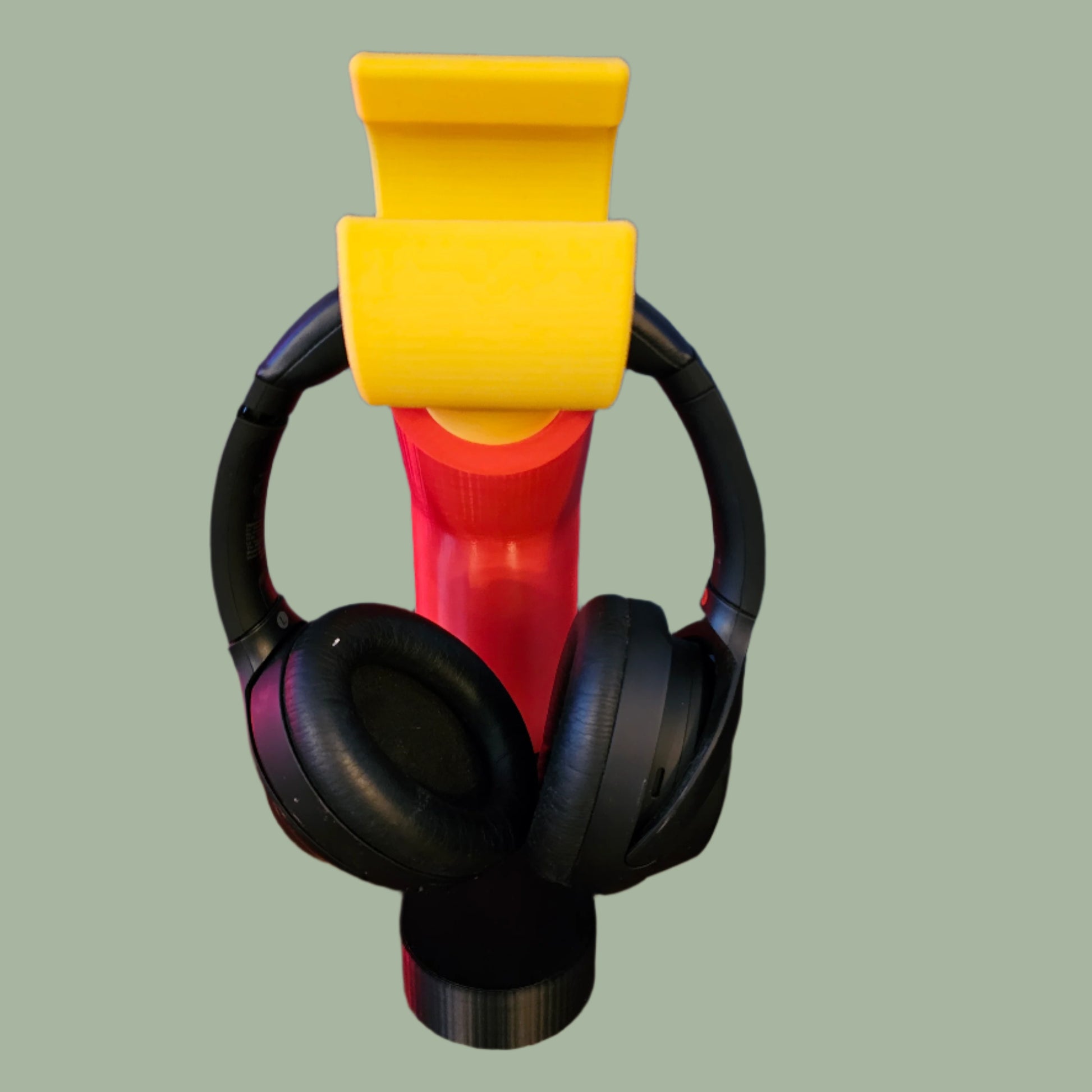 3D printed block style arm in various colours, with black base for wall or freestanding mounting, with chunky yellow hand to hold headphones or coats