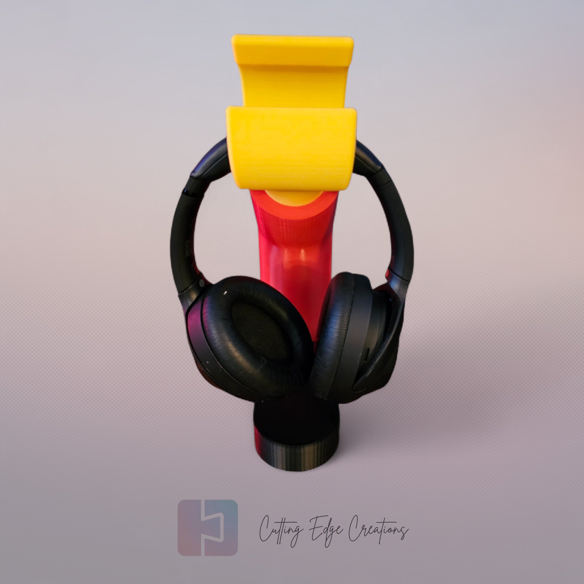3D printed block style arm in various colours, with black base for wall or freestanding mounting, with chunky yellow hand to hold headphones or coats