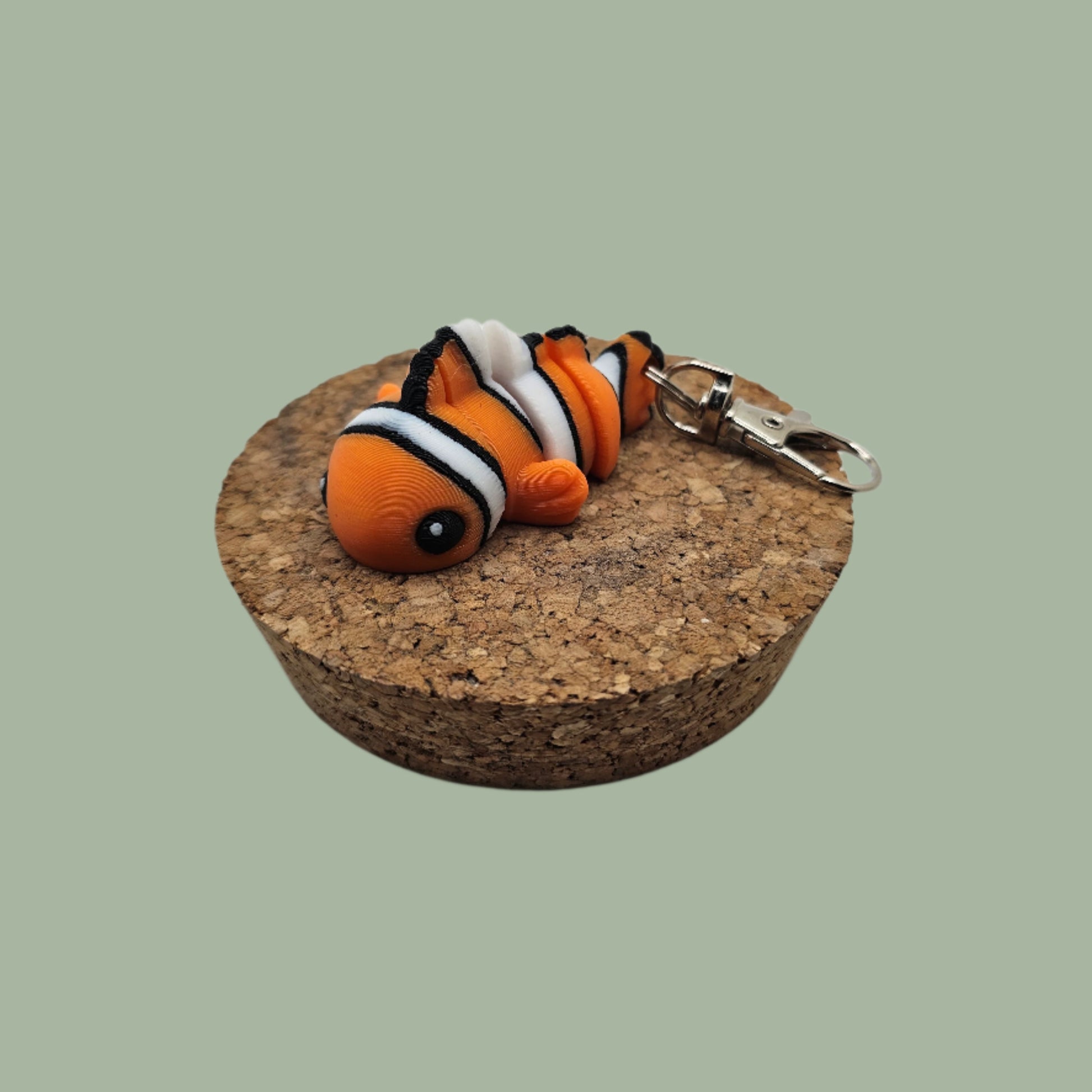 3D printed articulated orange, white, and black clownfish keyring