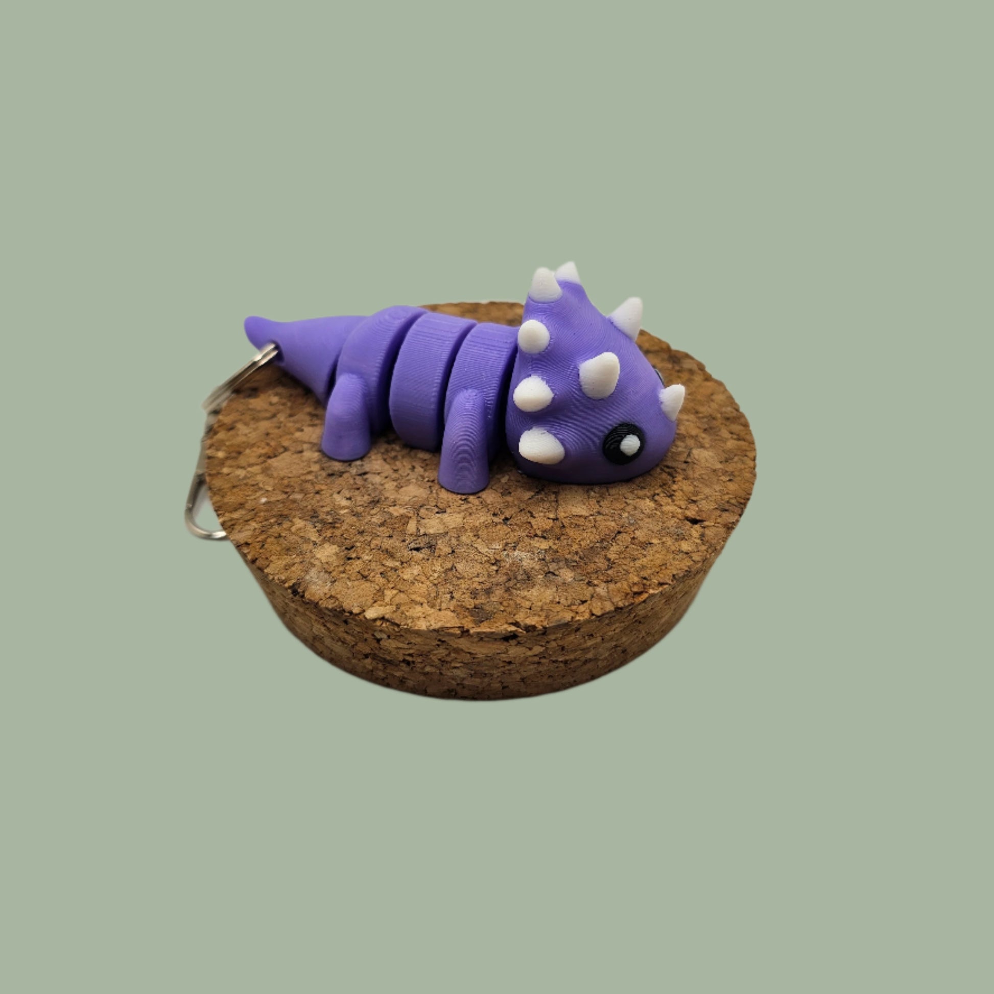 3D printed articulated purple and white dinosaur keyring