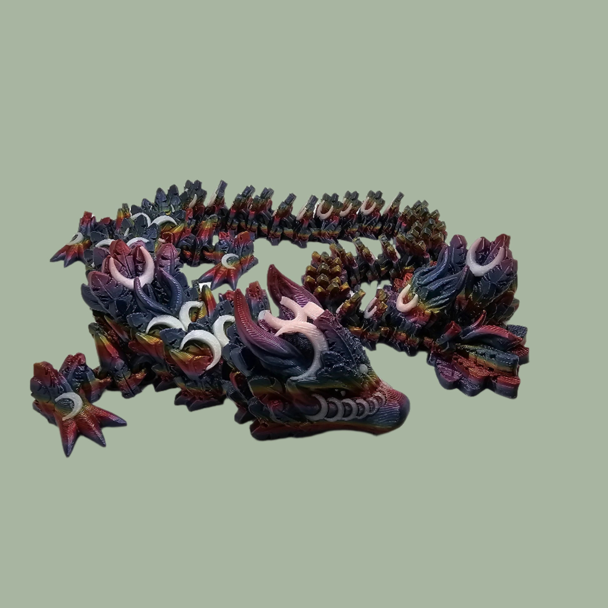 3D printed articulated dragon with crescent moon details, in a dark rainbow colour with glow in the dark moons
