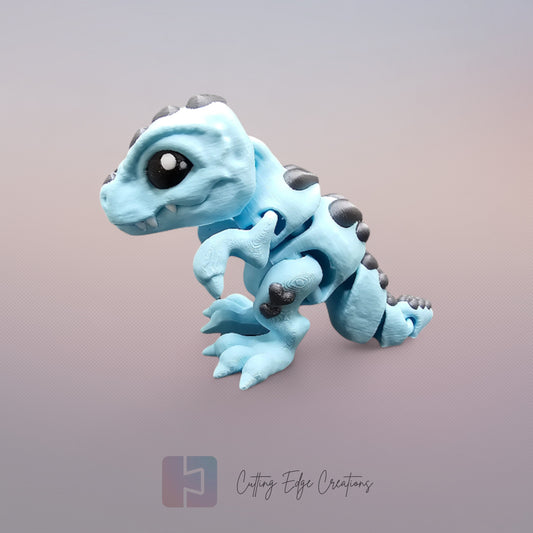 3D printed Love O’Saurus Rex dinosaur toy in light blue with black heart-shaped markings, designed as a flexible and posable fidget toy. Made in the UK by Cutting Edge Creations