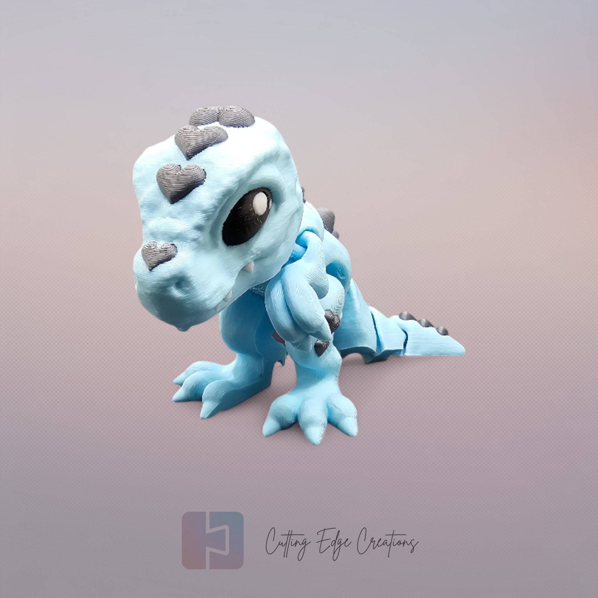 3D printed Love O’Saurus Rex dinosaur toy in light blue with black heart-shaped markings, designed as a flexible and posable fidget toy. Made in the UK by Cutting Edge Creations