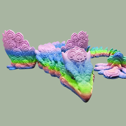 3D-printed Peacock Dragon figurine in pastel rainbow colours, featuring intricate feather-like scales and an articulated body. Handmade in the UK, available in medium, large, and X-large, with or without wings. A stunning, poseable dragon perfect for collectors and fantasy lovers
