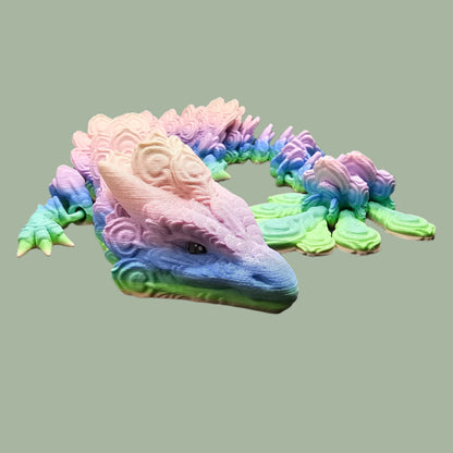 3D-printed Peacock Dragon figurine in pastel rainbow colours, featuring intricate feather-like scales and an articulated body. Handmade in the UK, available in medium, large, and X-large, with or without wings. A stunning, poseable dragon perfect for collectors and fantasy lovers