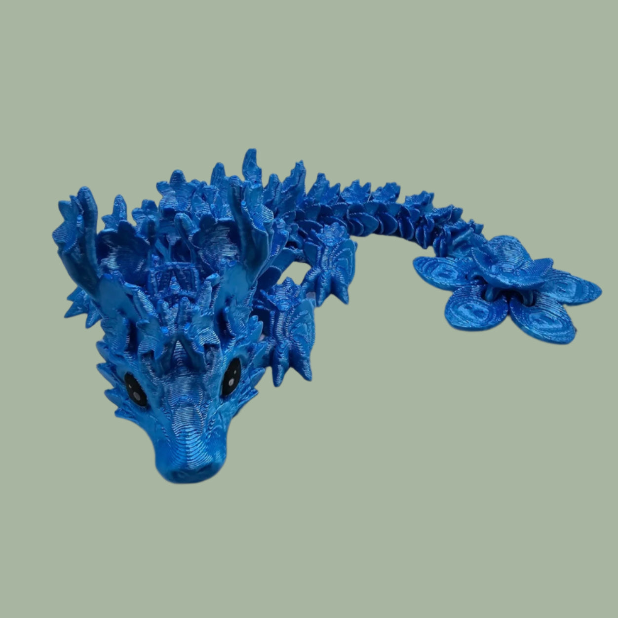 3D printed articulated dragon with cherry blossom details along the body and a flexi flower on the tail