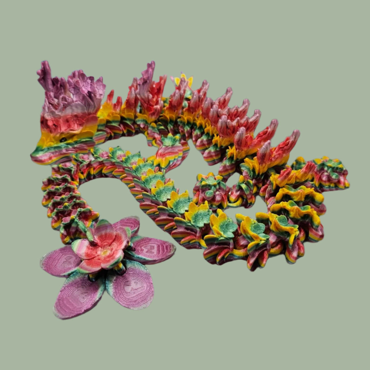 3D printed articulated dragon with cherry blossom details along the body and a flexi flower on the tail