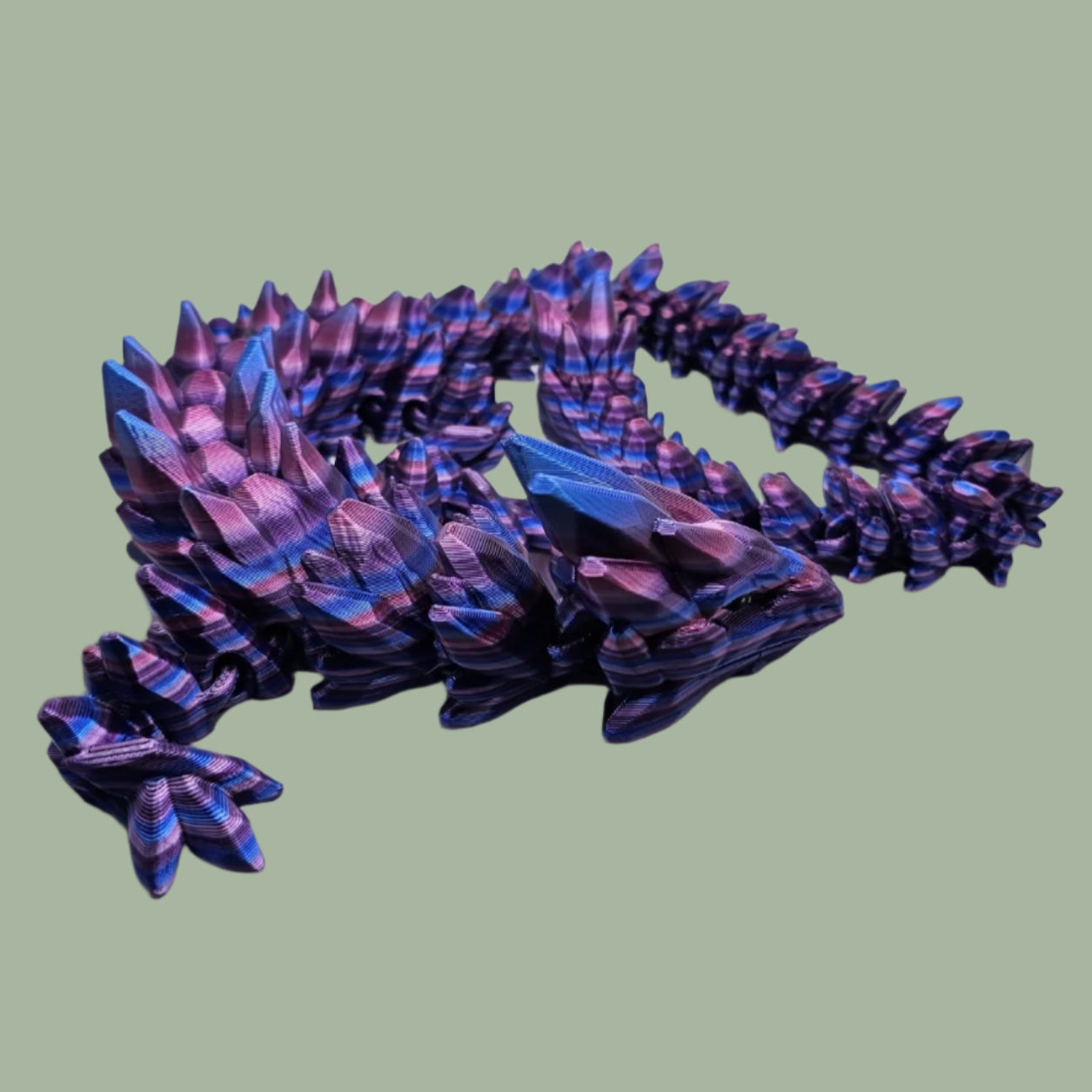 3D printed articulated dragon in a purple, blue, and pink colour