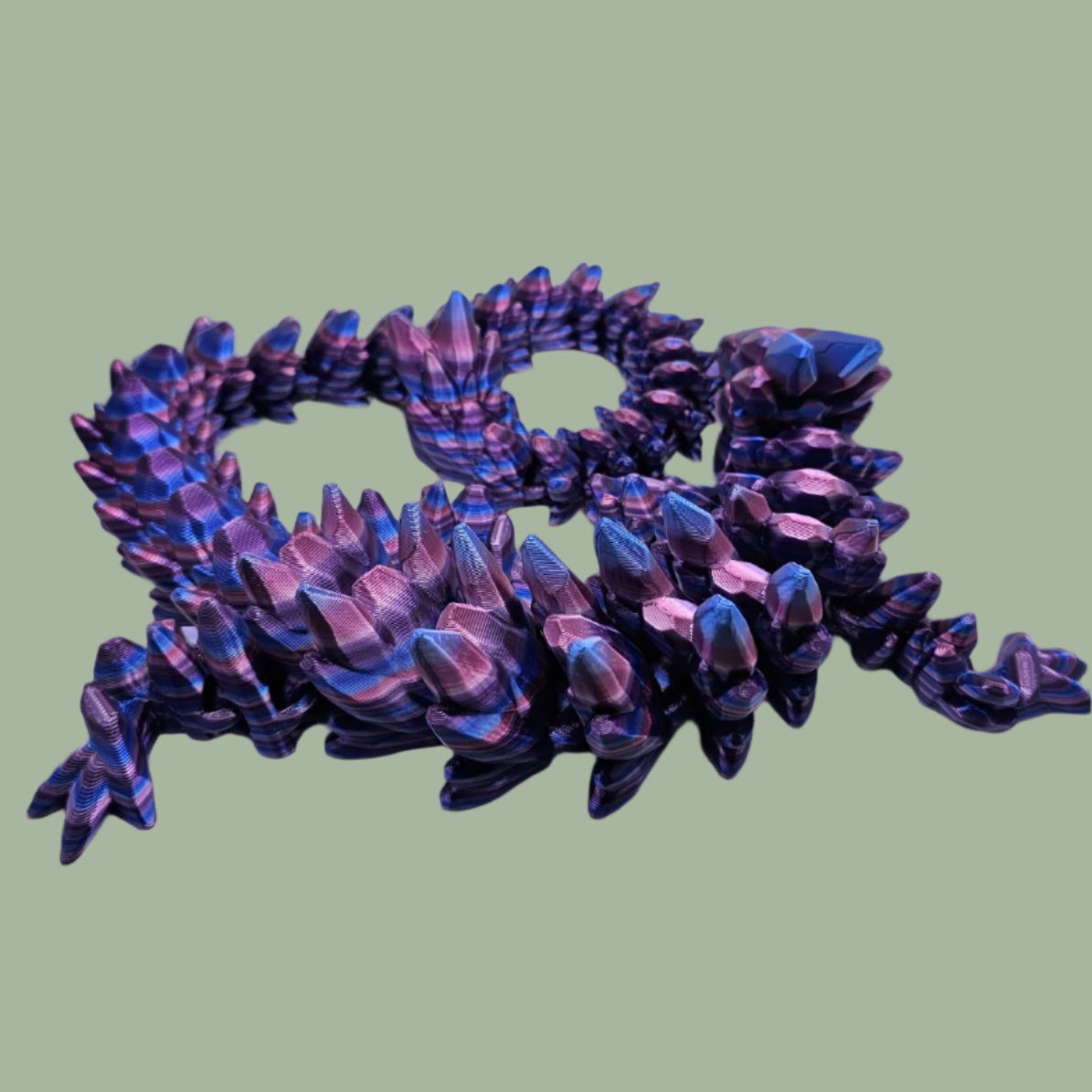 3D printed articulated dragon in a purple, blue, and pink colour