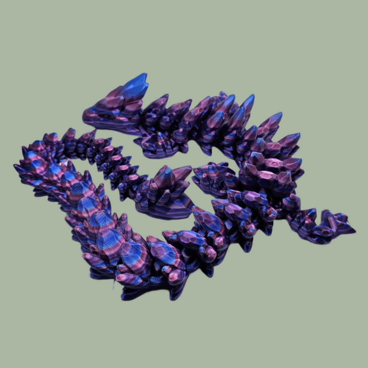 3D printed articulated dragon in a purple, blue, and pink colour
