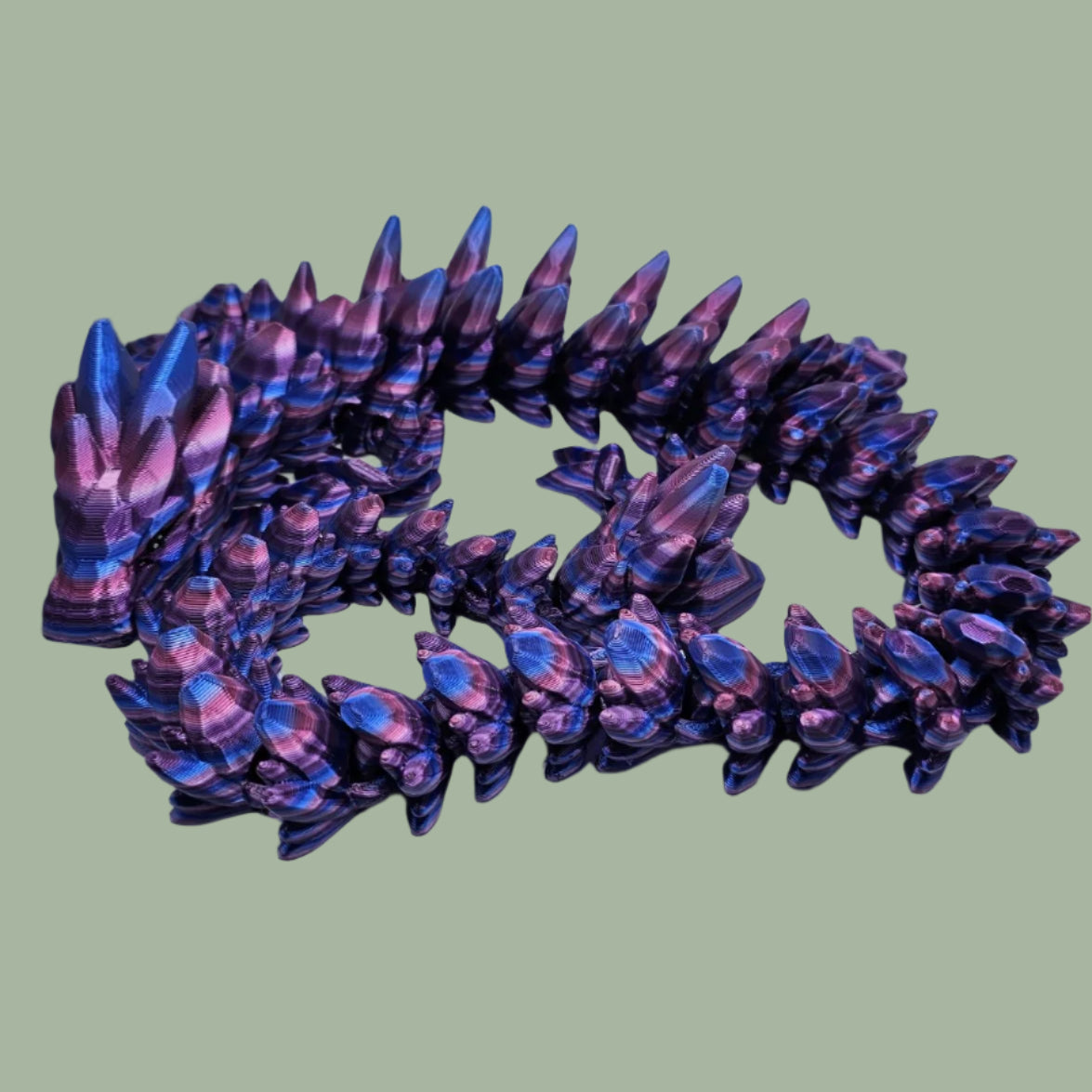3D printed articulated dragon in a purple, blue, and pink colour