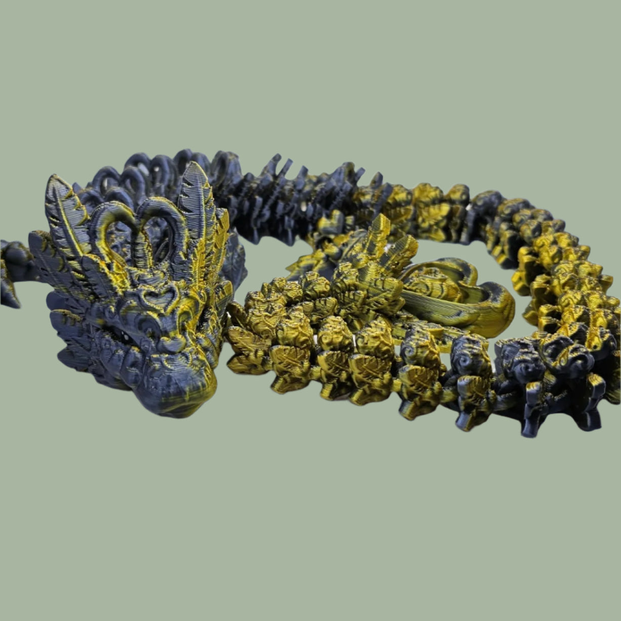 3D printed articulated dragon with heart details along the body and a spinning heart in the tail