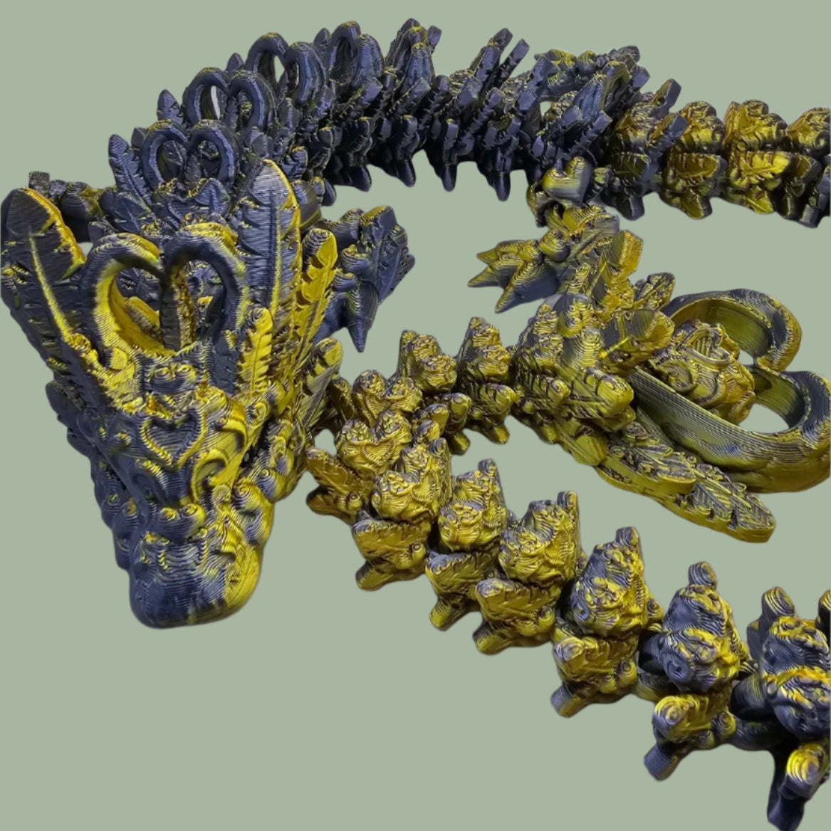 3D printed articulated dragon with heart details along the body and a spinning heart in the tail