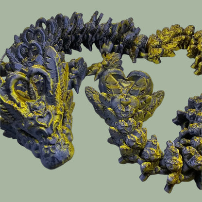3D printed articulated dragon with heart details along the body and a spinning heart in the tail