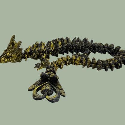 3D printed articulated dragon with heart details along the body and a spinning heart in the tail