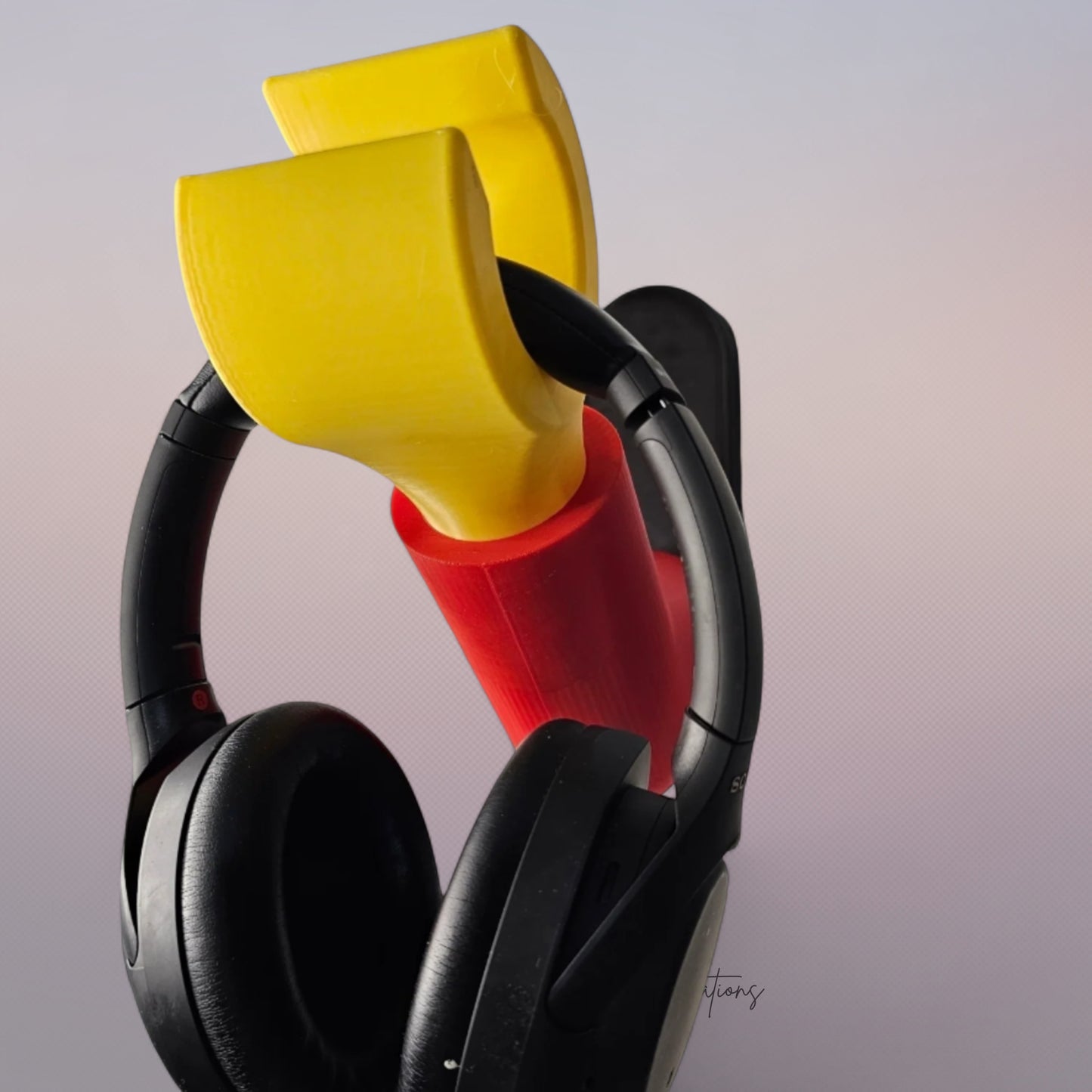 3D printed block style arm in various colours, with black base for wall or freestanding mounting, with chunky yellow hand to hold headphones or coats