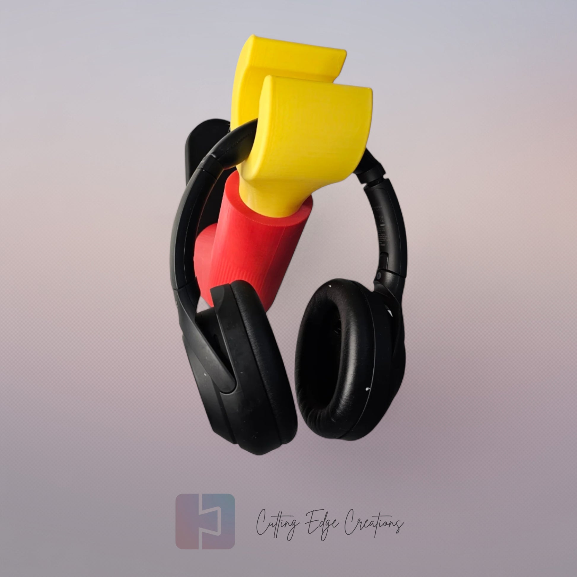3D printed block style arm in various colours, with black base for wall or freestanding mounting, with chunky yellow hand to hold headphones or coats