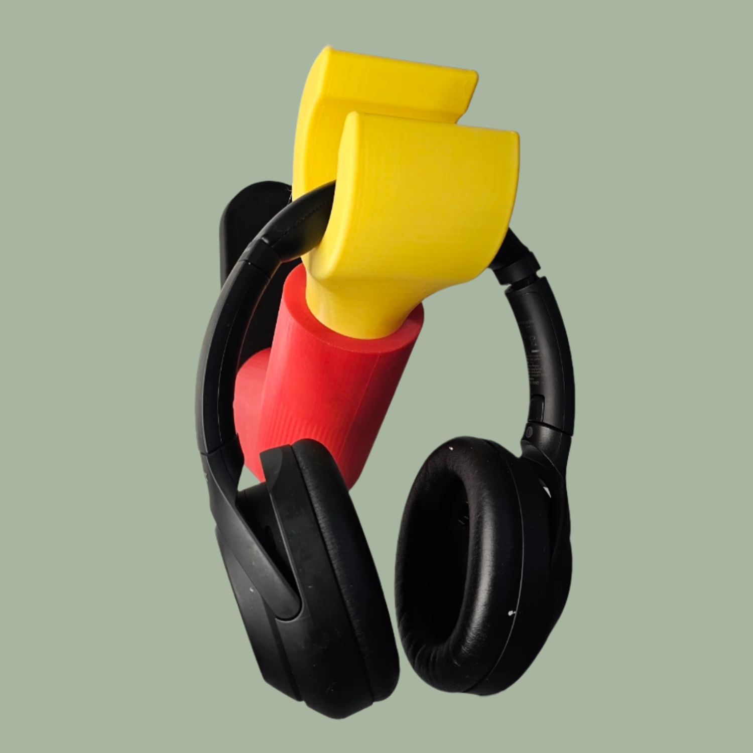 3D printed block style arm in various colours, with black base for wall or freestanding mounting, with chunky yellow hand to hold headphones or coats