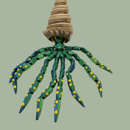 3D printed articulated green octopus with yellow spots and removeable shell hat