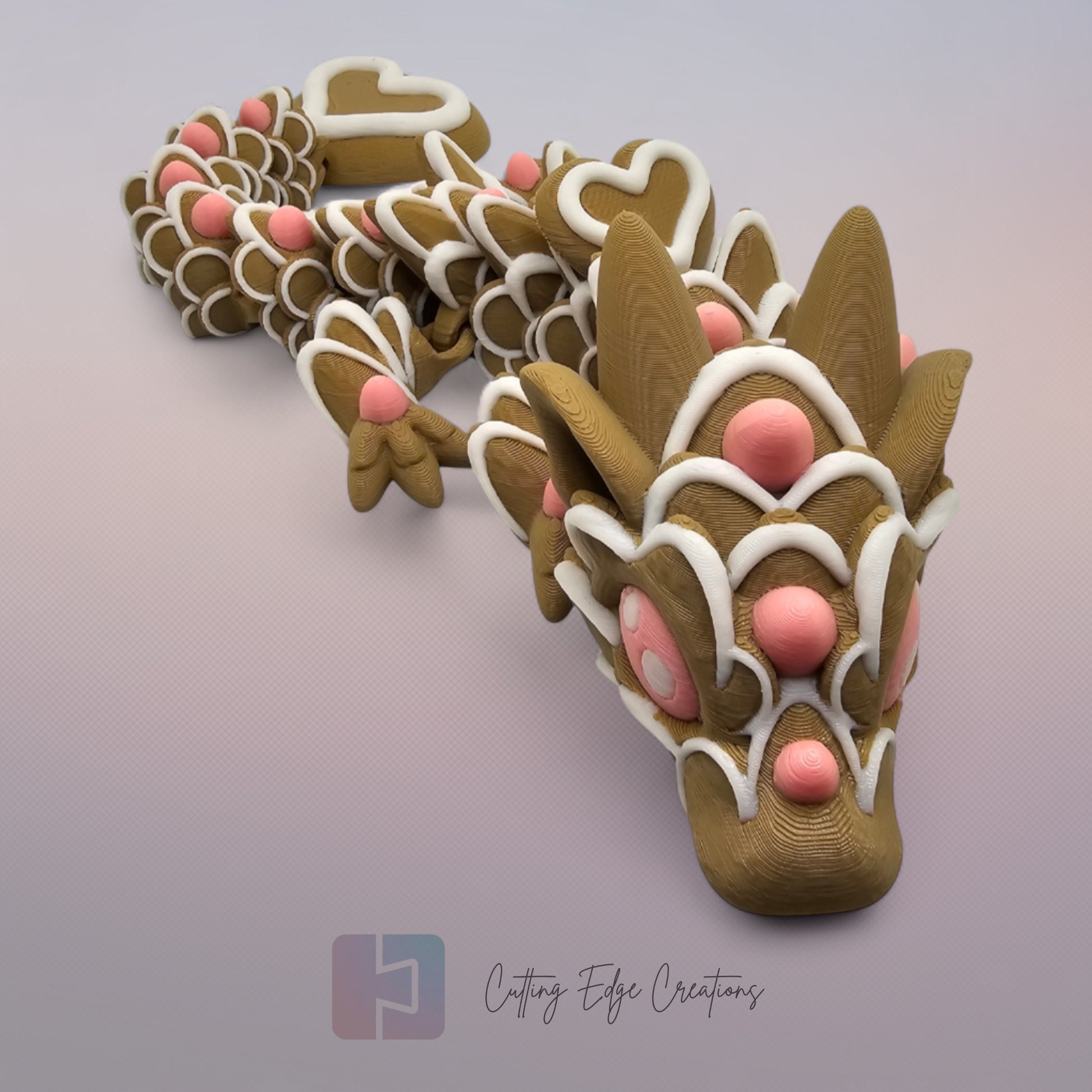 3D printed cookie style articulated dragon with pink and white icing details